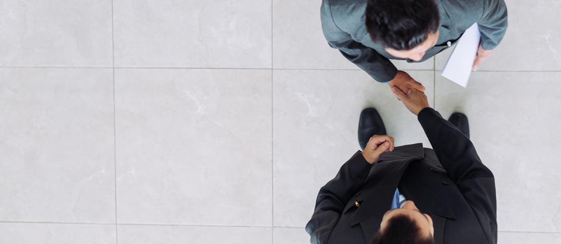 A photograph looking down on two business men shaking hands